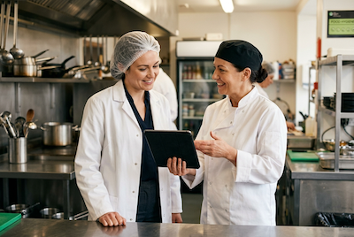 Chef showing digital HACCP records on a tablet during an inspection