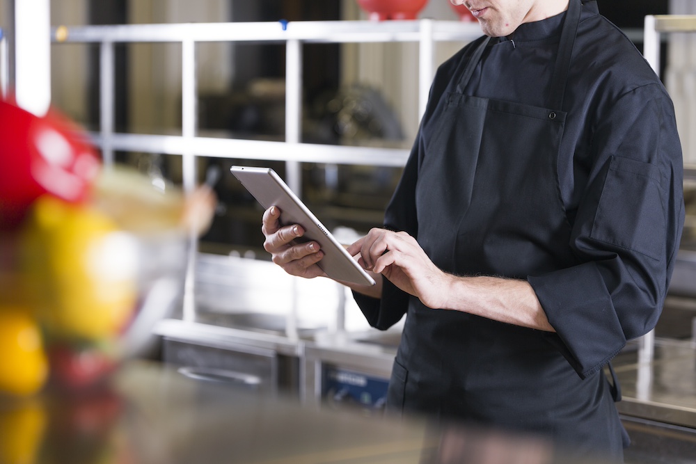 Chef replacing paper HACCP forms with SmartChef on a tablet