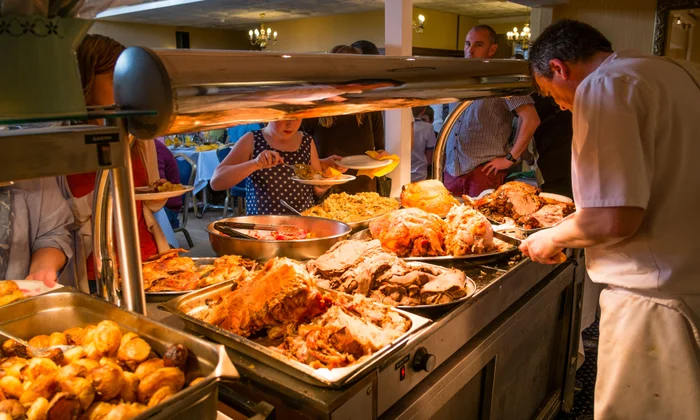 Chef serving customers at an Irish pub carvery counter