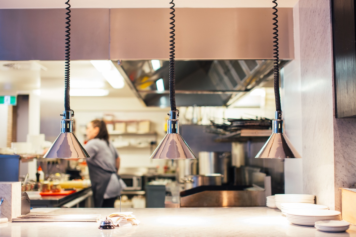Chef plating food in a busy restaurant kitchen